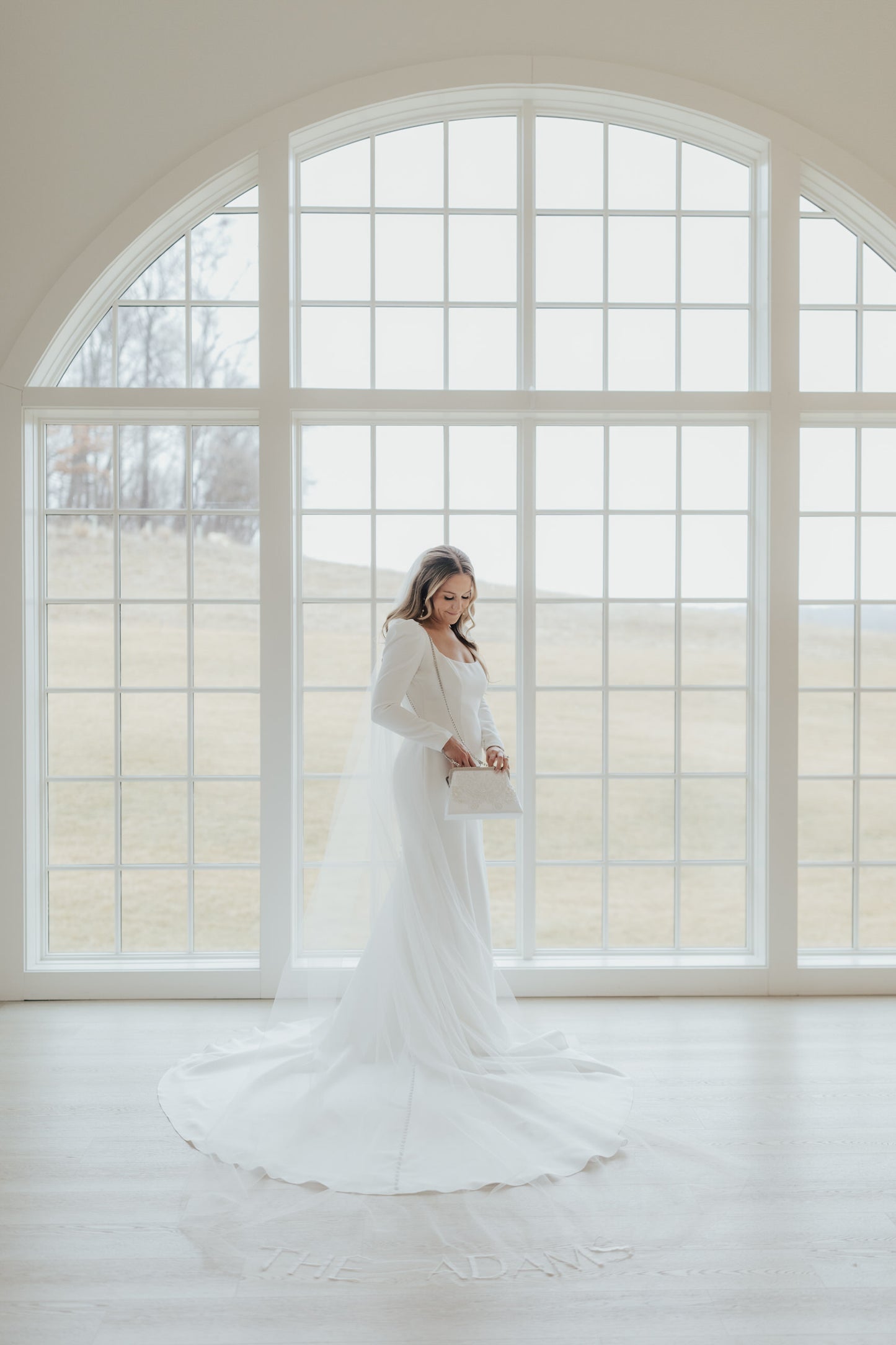 custom bespoke long wedding veil with embroidered words on bride in modest long sleeve dress