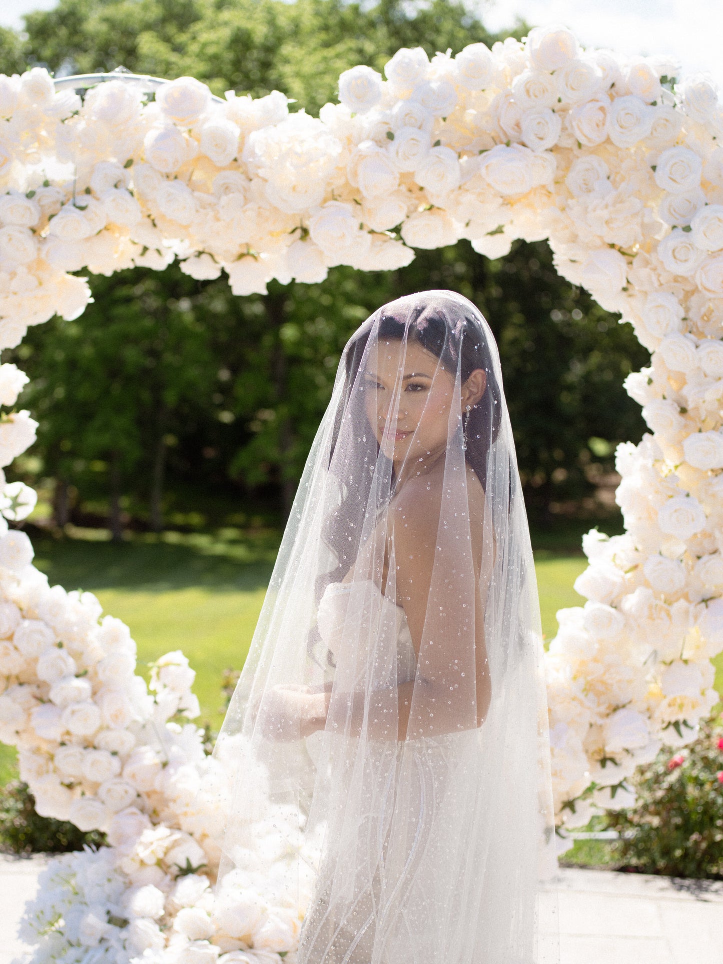 white rose wedding backdrop and bride in dew drop resin wedding veil