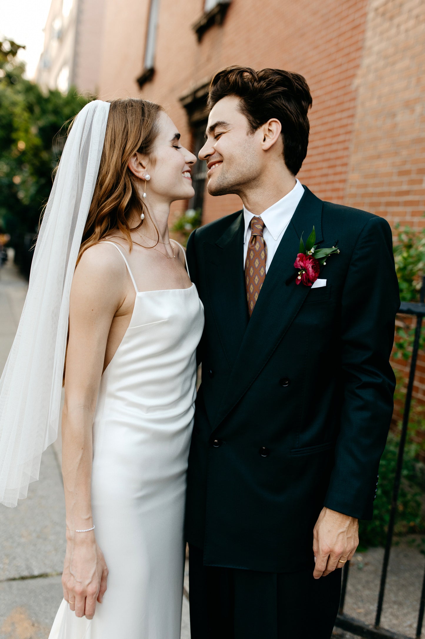 sophisticated simple bride and groom with bride in thin strap crepe gown and waist length bridal veil in light ivory