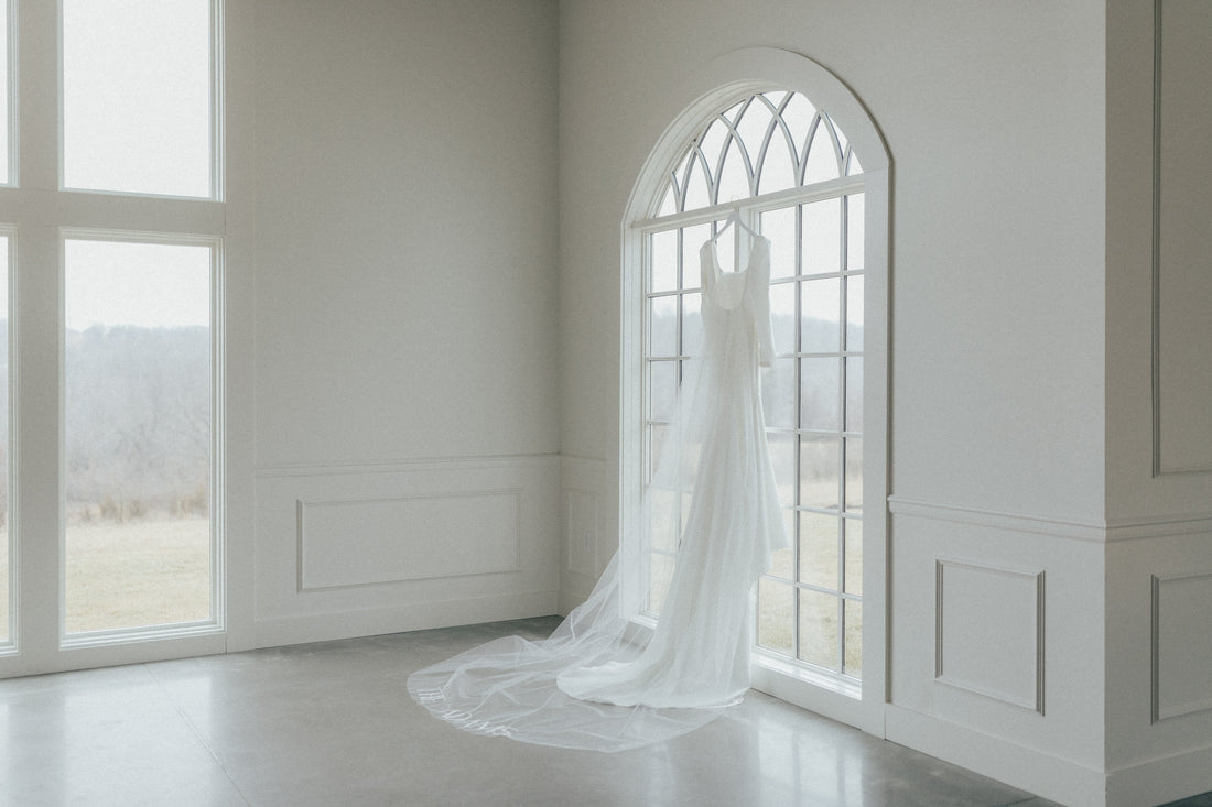 gorgeous wedding venue with windows and clean timeless mikado gown and long cathedral bridal veil with custom embroidered last name