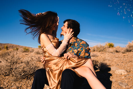 desert hippie engagement photo shoot with bride in gold and long sleeved with tulle wedding gloves