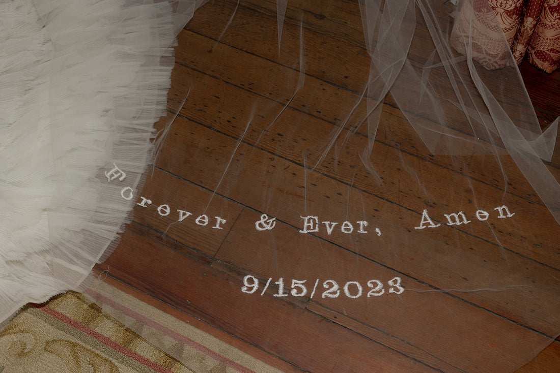 embroidered biblical phrase on long wedding veil with ruffle bridal gown