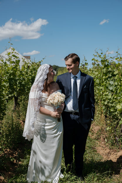  curvy bride in off shoulder rusched gown with lace mantilla fingertip veil