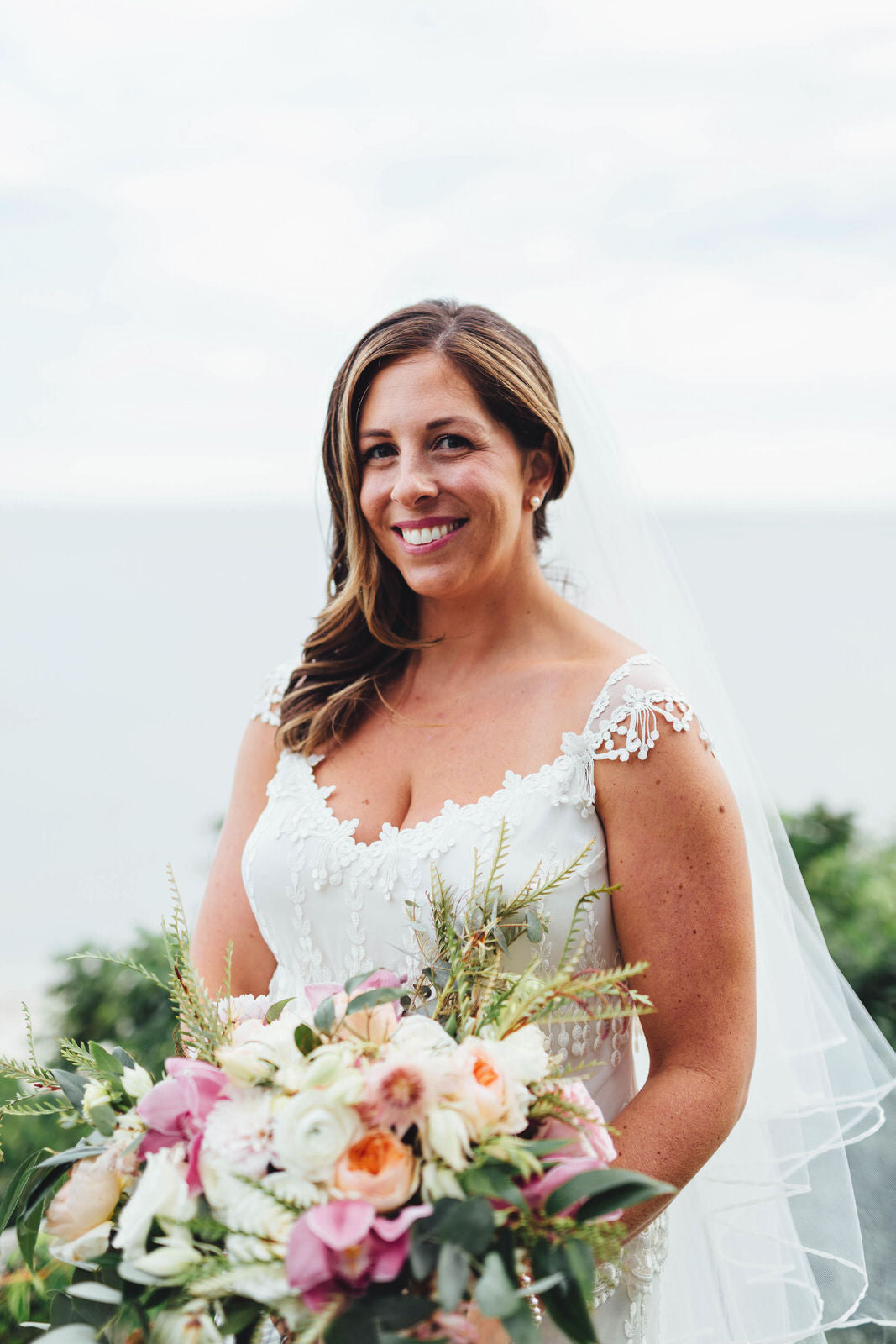 bohemian fringe lace wedding dress with ribbon cascade veil and wavy downdo hair