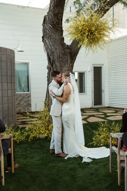 romantic backyard wedding with yellow florals and bride in chantilly knee length veil and soft tulle floor length scarf