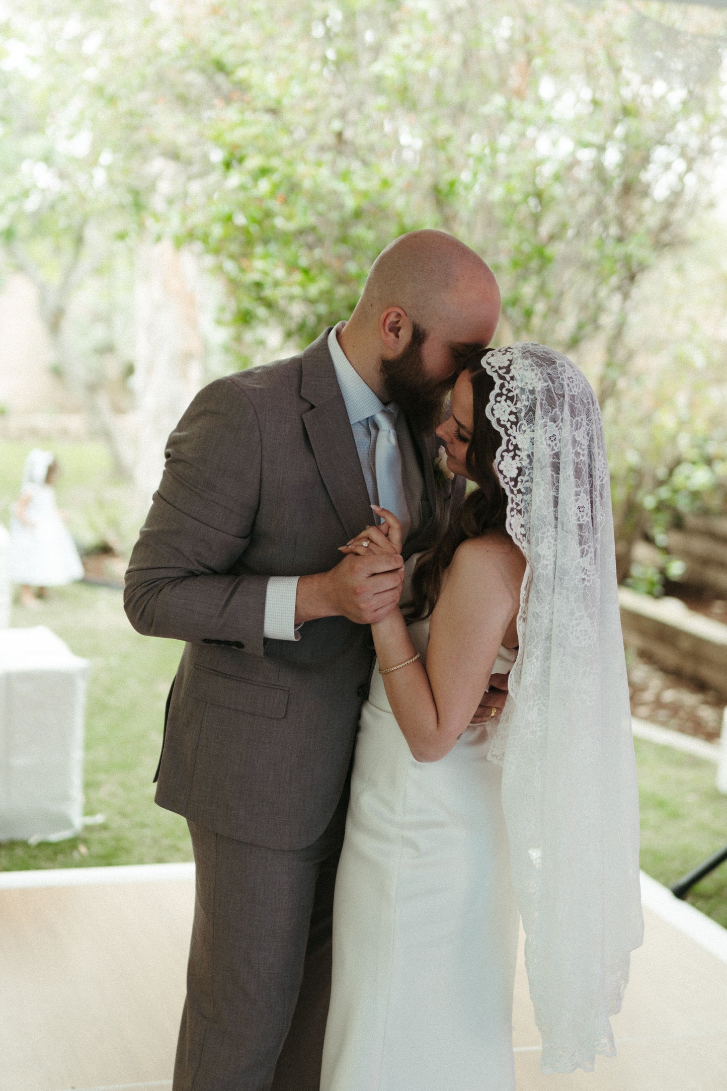 retro vintage inspired wedding with traditional mantilla lace wedding veil on top of head as bride dances at reception