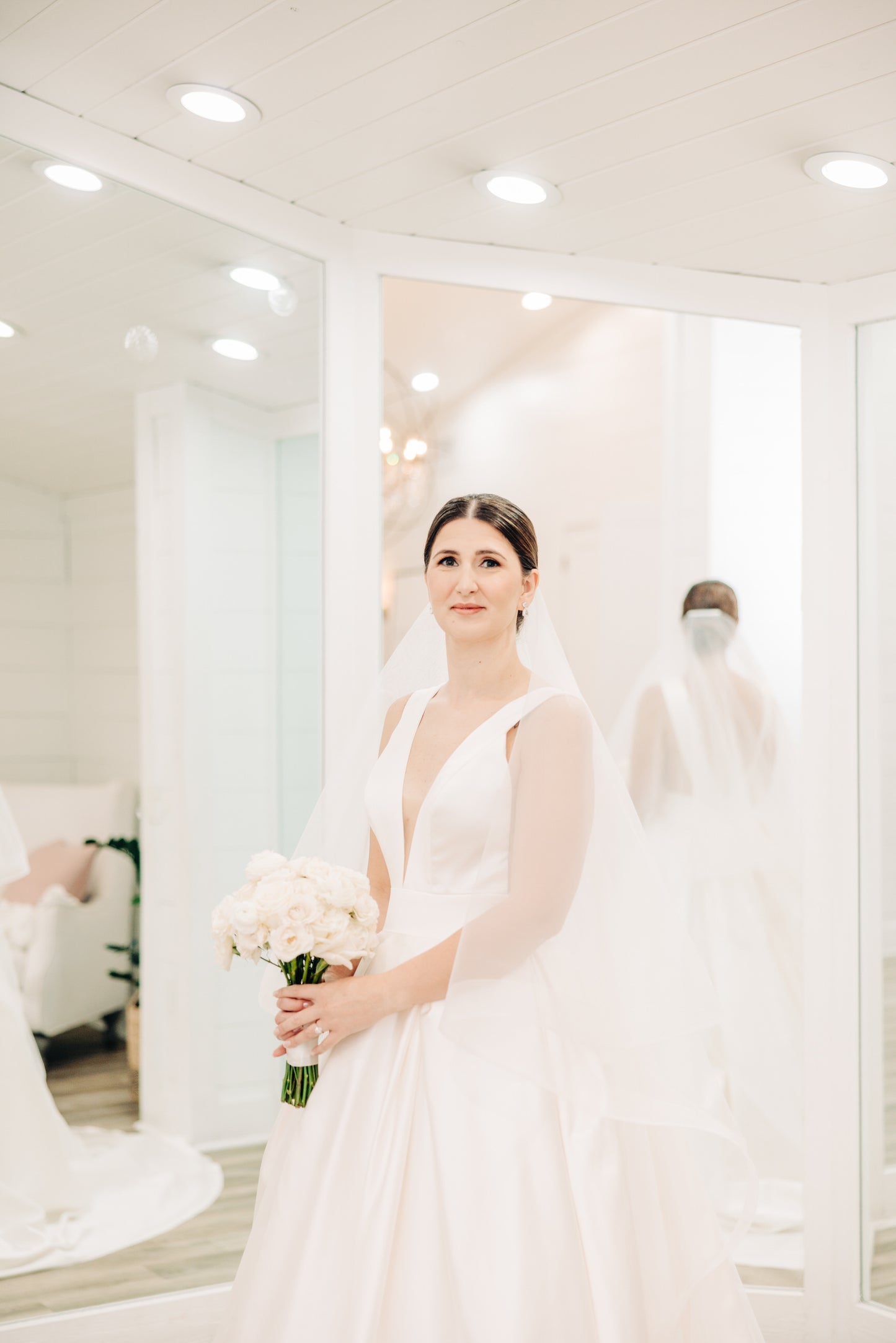 Bride in a white V neck wedding dress she sewed herself holding a bouquet
