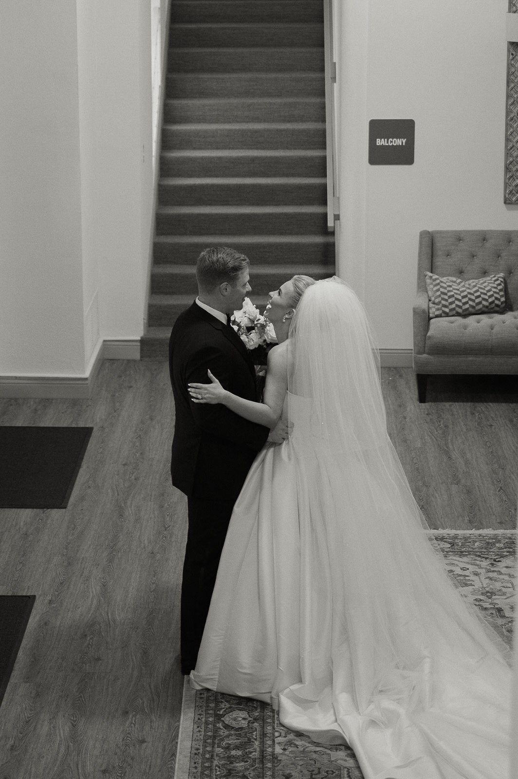Black and white photo of a bride and groom with extra long puffy four layer wedding veil over updo