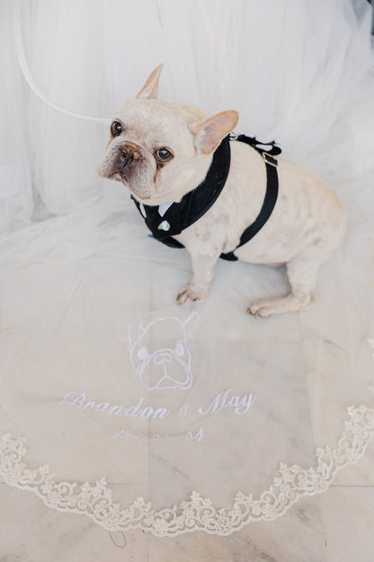 Dog wearing a black bow tie on a white veil with embroidery of the dog