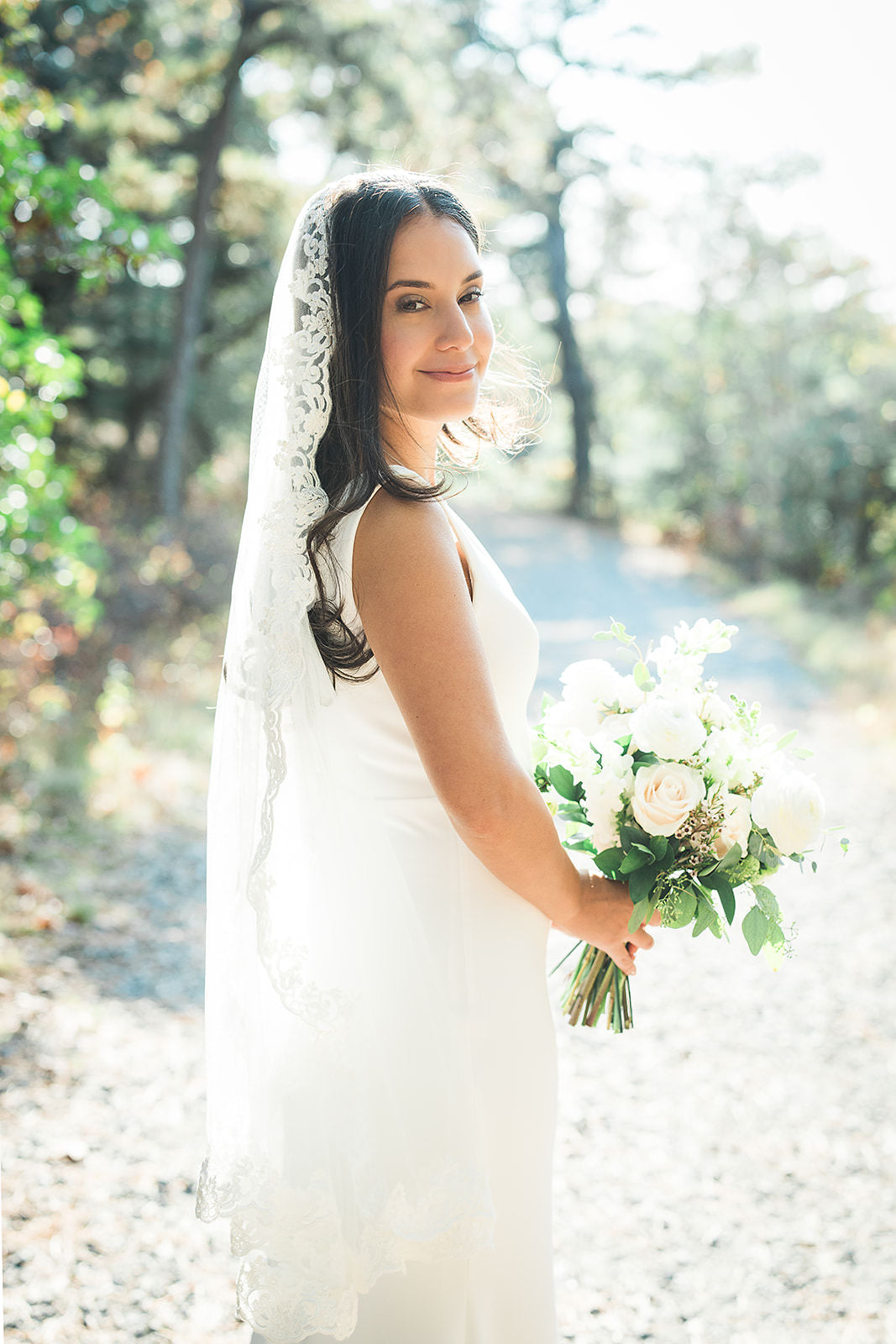 elegant scalloped off white fingertip wedding veil mantilla style on top of head