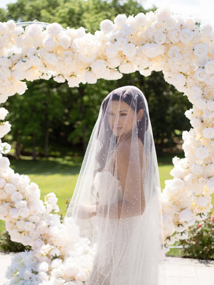 white rose wedding backdrop and bride in dew drop resin wedding veil