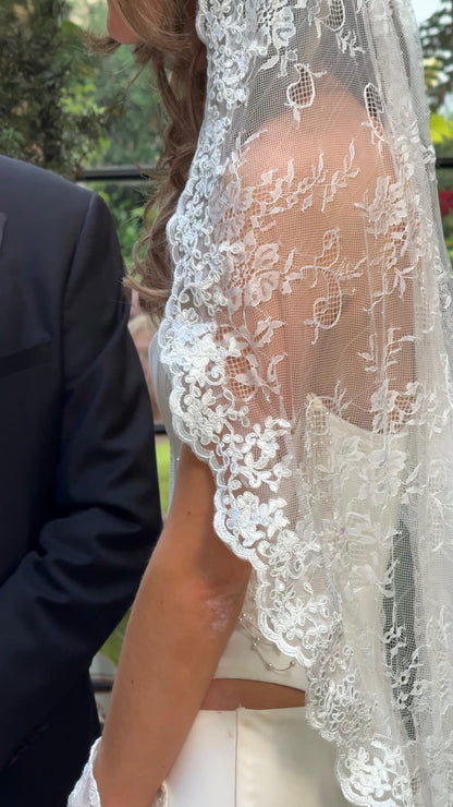 Close-up of a soft lace mantilla wedding veil with bustier corset