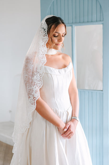 stunning bride in thin satin neck scarf and lace mantilla bridal veil with French scallop trim