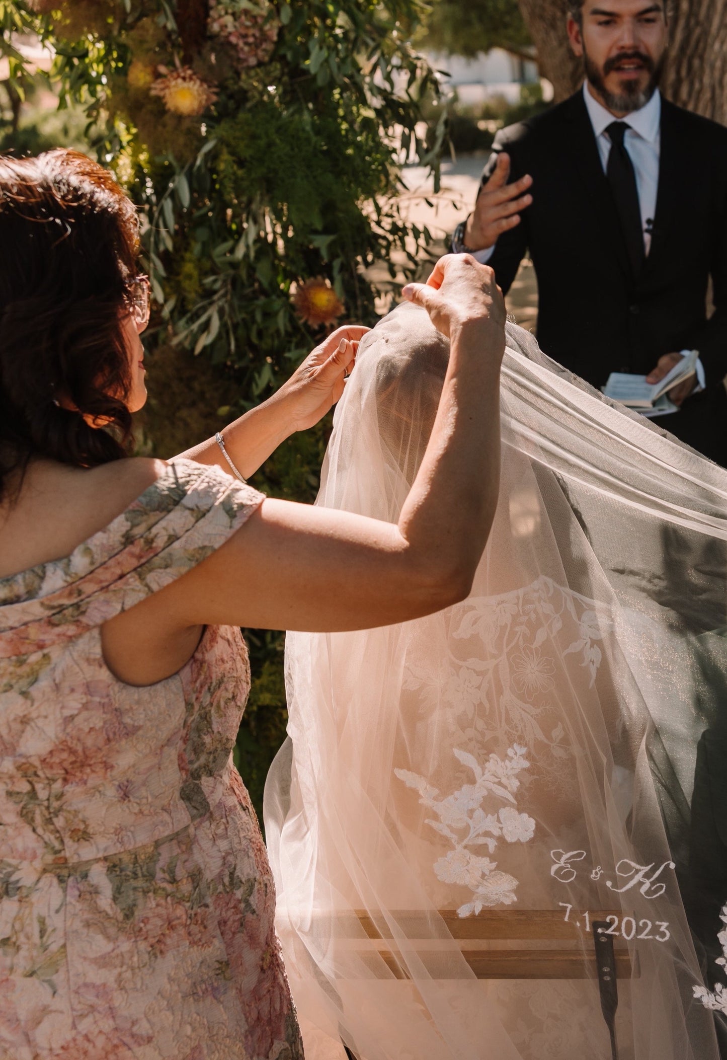 positioning unity veil with couple's initials over bride's shoulders for filipino traditional ceremony