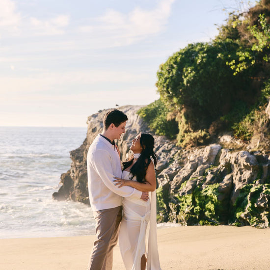 beach engagement photo shoot with goddess style white gown and long silk satin bridal gown