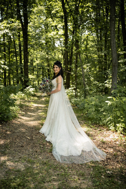 bride wearing sparkly cape veil for Norse wedding in forest