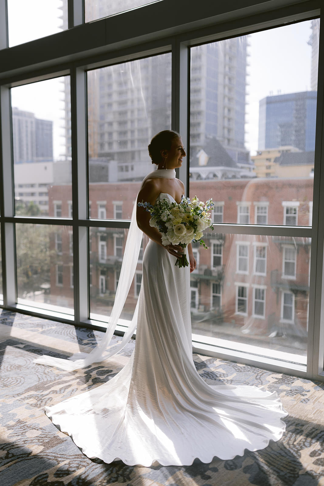 low wedding updo with long thin wedding scarf and white bouquet