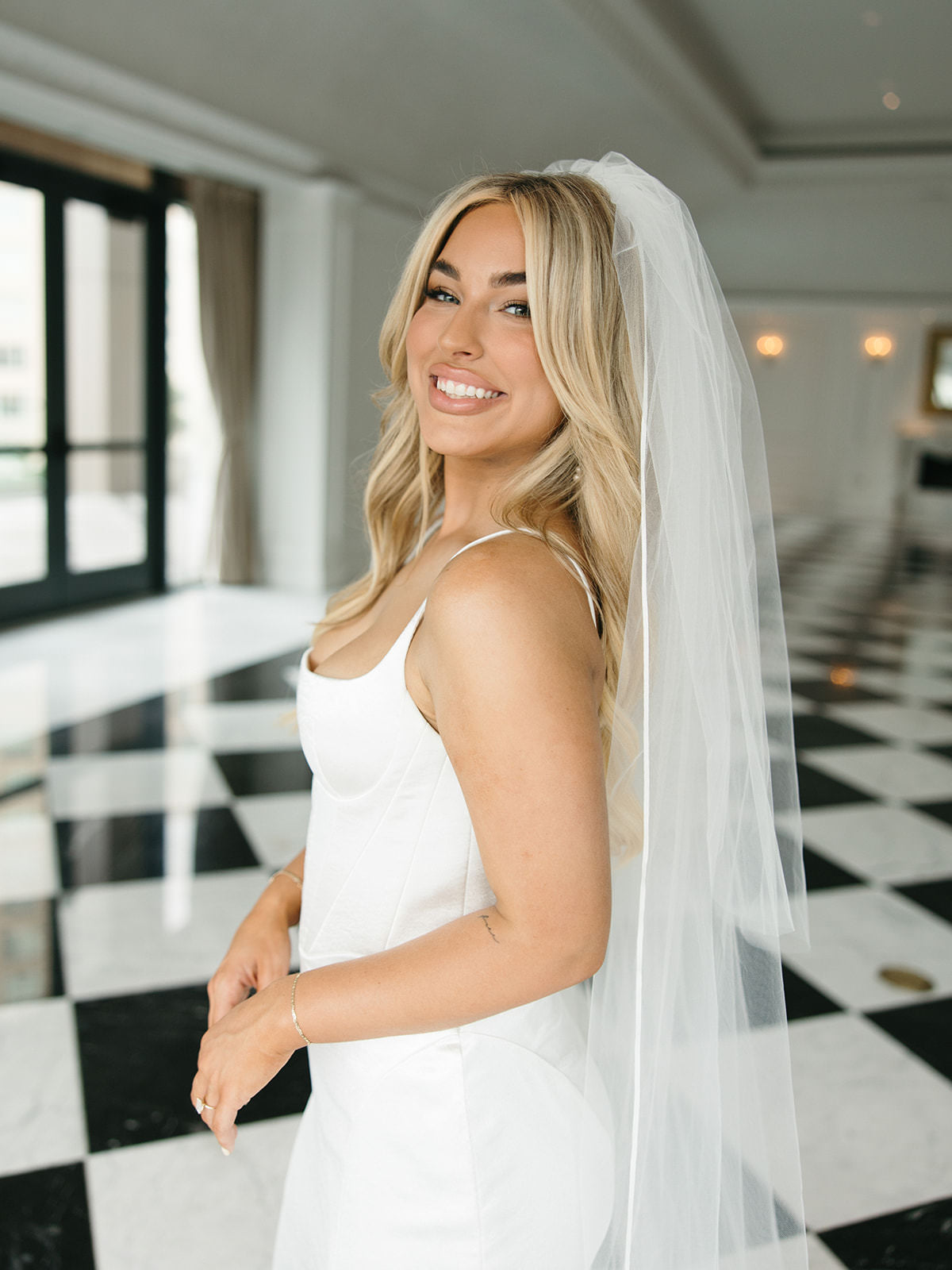 satin trimmed wedding veil with ribbon edge and blusher on bride in structured corset