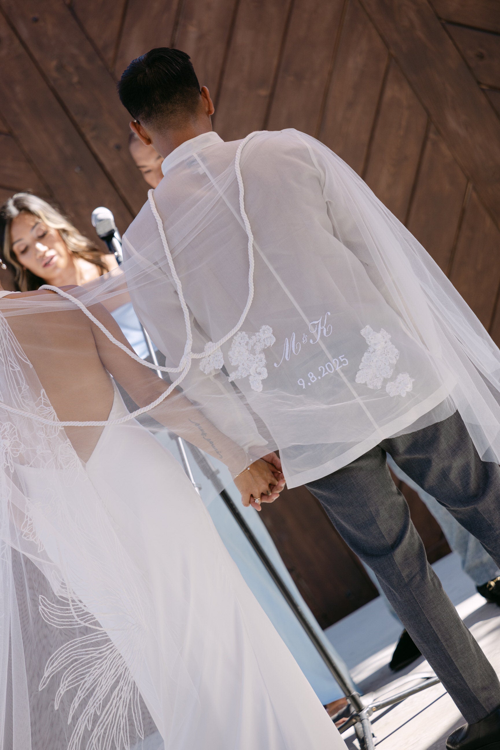 Couple wearing a white embroidered unity veil with personalized wedding date and lace applique